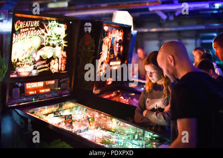 Printworks, London, UK. 11. August 2018. Menschen spielen Spiele bei den Spielen in London Expo Printworks, mit vielen originalen Spielautomaten, Flipper, Konsolen, Computerspiele und Sammlerstücke. Quelle: Matthew Chattle/Alamy leben Nachrichten Stockfoto