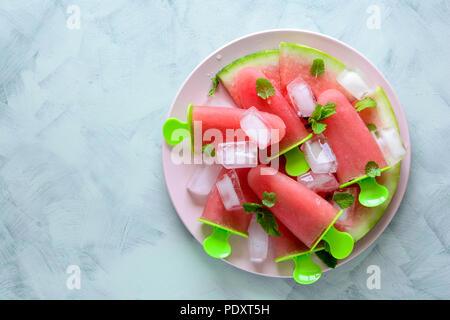 Hausgemachte Wassermelone Eis am Stiel mit Eis auf einem Teller. Ansicht von oben Stockfoto