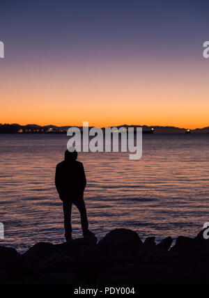 Mann, durch den Ozean mit Blick auf den Horizont. Stockfoto