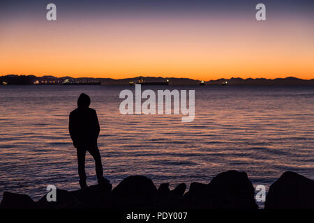 Mann, durch den Ozean mit Blick auf den Horizont. Stockfoto