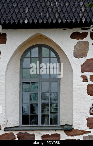 Mittelalterliche Kirche mit einem kleinen Fenster und Schindeldach Stockfoto