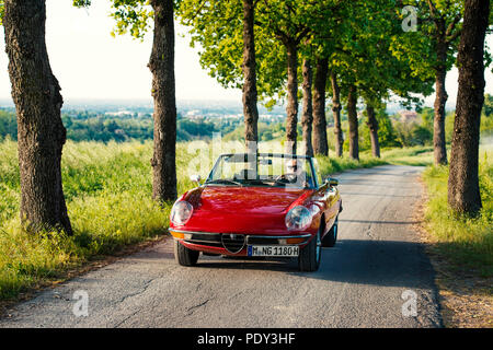 Rote Alfa Spider 2000 Cabrio auf Avenue, in Castelvetro, Modena, Emiglia-Romagna, Italien Stockfoto