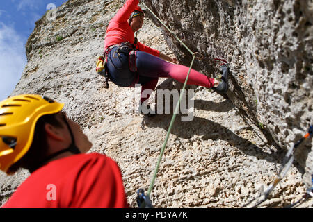 Bild der Frau Klettern in Fels und männliche Kursleiter Stockfoto