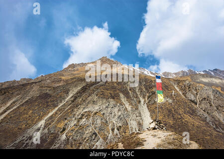 Kleine Stupa, aus Stein gebaut mit einer Flagge vor dem Hintergrund der schneebedeckten Gipfeln des Himalaya, Nepal. Stockfoto