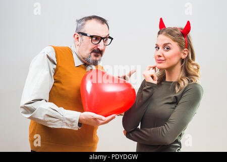 Nerdy Mann ist unsicher in seiner Freundin Liebe. Stockfoto