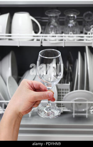 Spülmaschine, geöffnet und geladen mit Geschirr, Hand, aus sauberen Wein Glas, nach dem Waschen Stockfoto