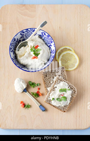 Hummus in eine Schüssel geben. Stockfoto