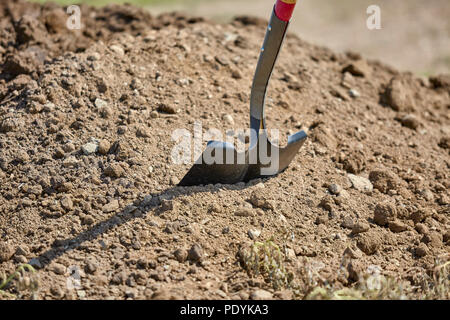 Nahaufnahme von einer Schaufel in einen Erdhaufen klemmt Stockfoto