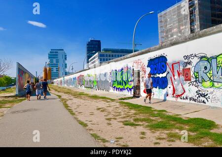 East Side Gallery - gemalt und graffitied Reste der Berliner Mauer in Friedrichshain, Berlin, Deutschland. Heißer Sommer am Nachmittag im August 2018. Stockfoto