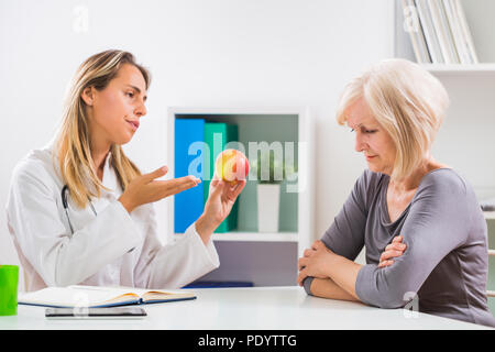 Ältere Frau Patienten ablehnen, Frucht, die für Ihre Gesundheit gut ist, um zu essen. Stockfoto