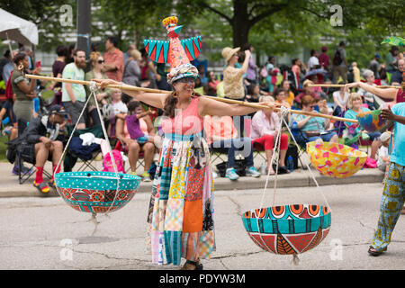 Cleveland, Ohio, USA - Juni 9, 2018 Frauen mit bunten Outfits die Körbe auf einem Stick über ihre Schultern auf die abstrakte Kunst Festival Parad Stockfoto