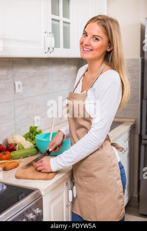Schöne Frau, die Mahlzeit in Ihrer Küche. Stockfoto