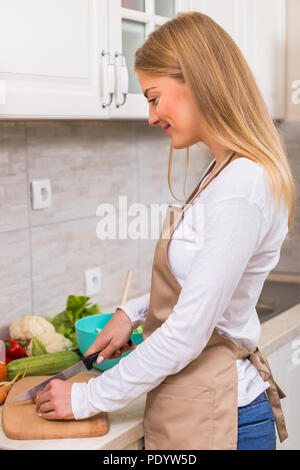 Schöne Frau, die Mahlzeit in Ihrer Küche. Stockfoto
