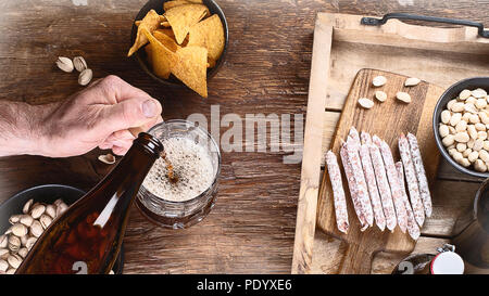 Man Bier aus Flasche in Glas Stockfoto