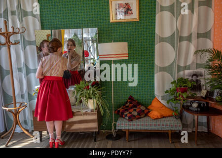 Ein sowjetisches Mädchen macht einen Make-up auf einen Spiegel in Ihrer Wohnung. Wiederaufbau der Chruschtschows Tauwetter während der "Zeit und Epoche" Festival in Moskau Stockfoto