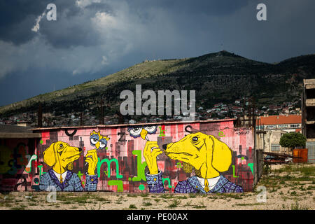 Ein Graffiti mit zwei anthropomorphen Hunde auf einem stillgelegten Wand von Mostar Zentrum ((Herzegovina-Neretva, Bosnien-herzegowina). Stockfoto