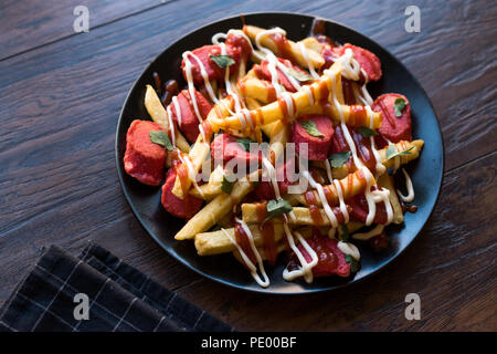 Hausgemachte peruanischen Salchipapa Pommes mit Wurstscheiben, Ketchup und Mayonnaise. Traditionelle Speisen. Stockfoto