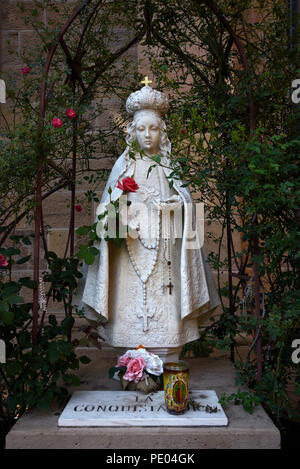 Rosenkranz hängen von einer Steinstatue von La Conquistadora, und die Jungfrau Maria, die in der Kathedrale Basilika des Hl. Franziskus von Assisi in Santa Fe, NM Stockfoto