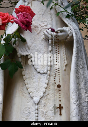 Rosenkranz hängen von einer Steinstatue von La Conquistadora, und die Jungfrau Maria, die in der Kathedrale Basilika des Hl. Franziskus von Assisi in Santa Fe, NM Stockfoto