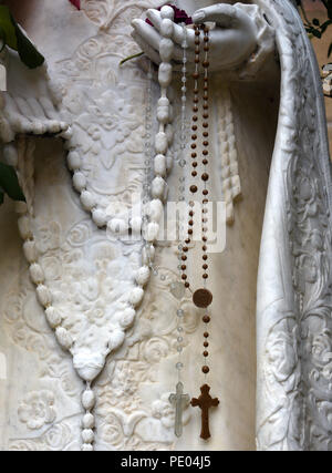 Rosenkranz hängen von einer Steinstatue von La Conquistadora, und die Jungfrau Maria, die in der Kathedrale Basilika des Hl. Franziskus von Assisi in Santa Fe, NM Stockfoto