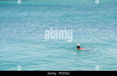 Ältere Mann Schwimmen im Meer in der Sonne Stockfoto
