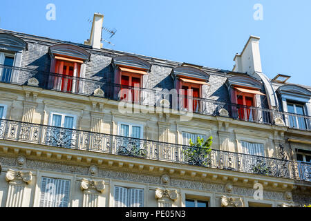 Blick von unten auf der Straße von einem typischen Pariser, opulent - Gebäude von Haussmann-gebäude Stil mit geschliffenen Steinen Fassade suchen, geschnitzten Ornamenten und Balkon. Stockfoto