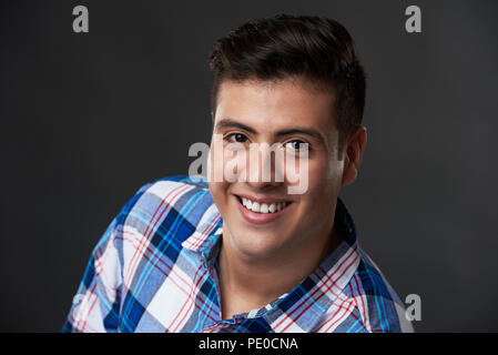 Headshot Portrait von junge lächelnde brünett Mann im Studio Hintergrund Stockfoto