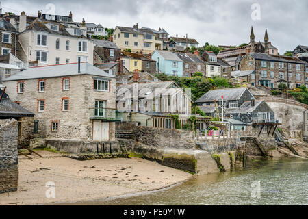 Eine typische Landschaft von Cornwall Bild Der kleine Strand bei Polruan Kai auf der Fowey Mündung durch alte Marine Gebäude und Dorf Wohnungen umgeben. Stockfoto