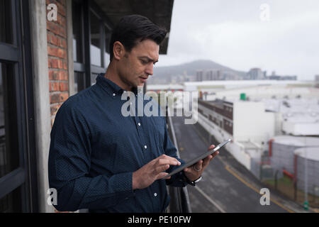 Geschäftsmann mit digital-Tablette in Balkon Stockfoto