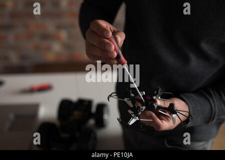 Männliche Elektrotechnik Instandsetzung einer Drohne Stockfoto