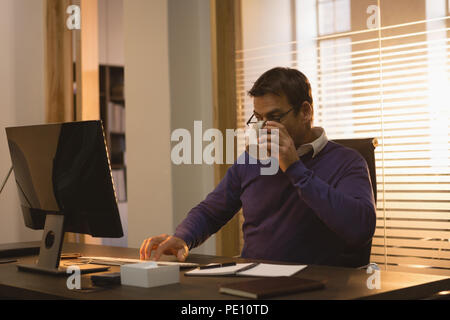 Unternehmer/in bei der Verwendung von Desktop-PC am Schreibtisch Stockfoto