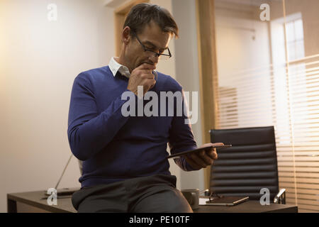 Geschäftsmann mit digital-Tablette am Schreibtisch Stockfoto