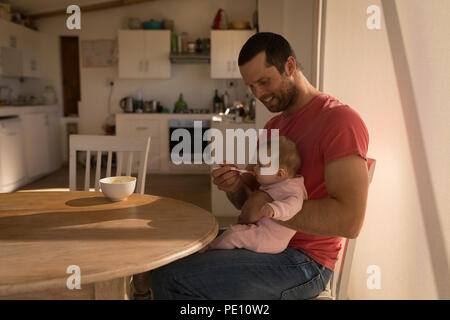 Vater Fütterung sein baby boy mit Löffel Stockfoto