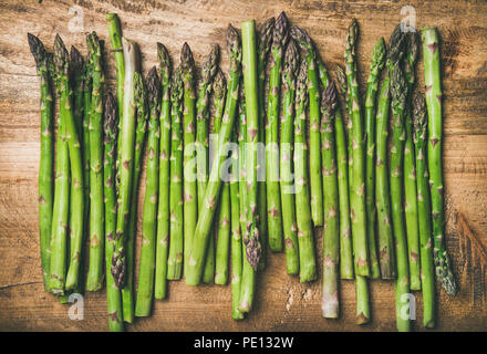 Roh ungekocht grüner Spargel in der Zeile über Holz- Hintergrund Stockfoto