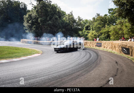 Ein Cabrio Jaguar Sportwagen spinnt seine Reifen, Erstellen von Rauch, auf einer Schiene am Goodwood Festival der Geschwindigkeit 2018. Stockfoto