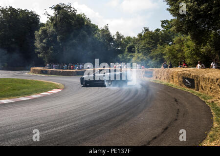 Ein Cabrio Jaguar Sportwagen spinnt seine Reifen, Erstellen von Rauch, auf einer Schiene am Goodwood Festival der Geschwindigkeit 2018. Stockfoto