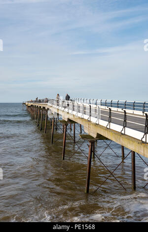 Touristen zu Fuß entlang der historischen Pier in Saltburn-by-the-Sea, North Yorkshire, England. Stockfoto