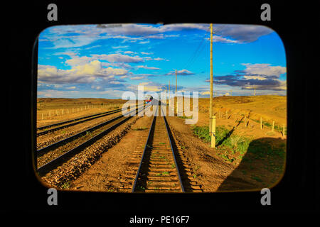 Die Gobi, Mongolei - von Süden kommend, die Transmongolische Eisenbahn verbindet China und Russland, der eine atemberaubende Schönheiten aus der hinteren Fenster Stockfoto