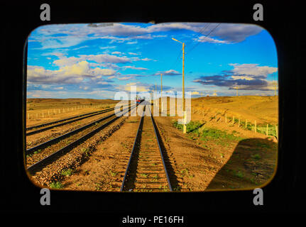 Die Gobi, Mongolei - von Süden kommend, die Transmongolische Eisenbahn verbindet China und Russland, der eine atemberaubende Schönheiten aus der hinteren Fenster Stockfoto