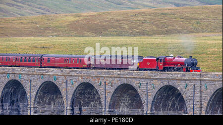 Die cumbrian Mountain Express, gezogen von historischen Dampflok Nr. 45699 Galatea, überquert die Ribblehead Viadukt in North Yorkshire als eisenbahnfreunde zum 50. Jahrestag des Ende der regulären Mainline steam Dienste markieren. Stockfoto