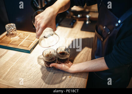 Junge männliche Barista macht frischen schwarzen Kaffee im Cafe. Barkeeper arbeiten in der Cafeteria, Barmixer espresso bereitet Stockfoto