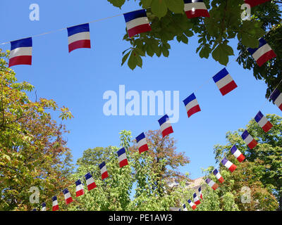 Französische String Flag Banner in den Zeilen in einem Sommer blauer Himmel in Murviel-lès-Béziers, Frankreich Stockfoto