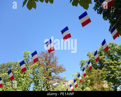 Französische String Flag Banner in den Zeilen in einem Sommer blauer Himmel in Murviel-lès-Béziers, Frankreich Stockfoto