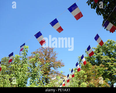 Französische String Flag Banner in den Zeilen in einem Sommer blauer Himmel in Murviel-lès-Béziers, Frankreich Stockfoto