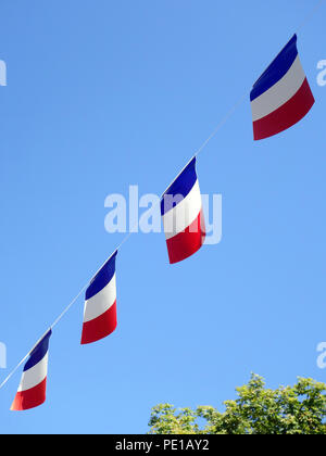 Französische String Flag Banner in den Zeilen in einem Sommer blauer Himmel in Murviel-lès-Béziers, Frankreich Stockfoto