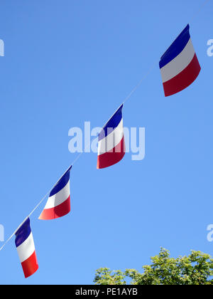 Französische String Flag Banner in den Zeilen in einem Sommer blauer Himmel in Murviel-lès-Béziers, Frankreich Stockfoto