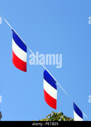 Französische String Flag Banner in den Zeilen in einem Sommer blauer Himmel in Murviel-lès-Béziers, Frankreich Stockfoto