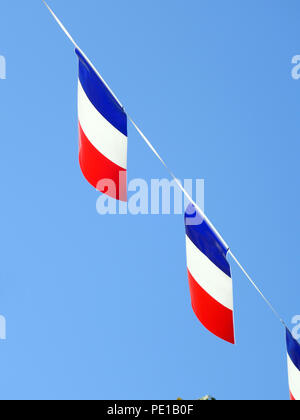 Französische String Flag Banner in den Zeilen in einem Sommer blauer Himmel in Murviel-lès-Béziers, Frankreich Stockfoto