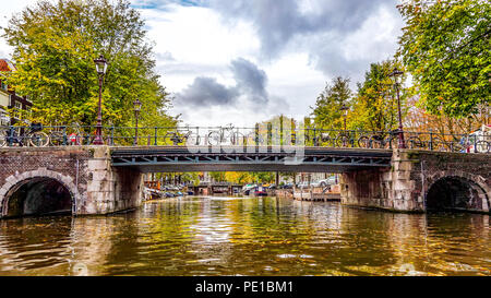 Blick auf eine Brücke über die Brouwersgracht (Brauer Canal) von einem Kanal tour Boot in der Herengracht im Herzen der Altstadt von Amsterdam, Holland Stockfoto