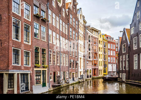 Historische Häuser auf dem Ouderzijds Achterburgwal Kanal im Rotlichtmilieu des alten Stadtzentrums von Amsterdam, Niederlande Stockfoto